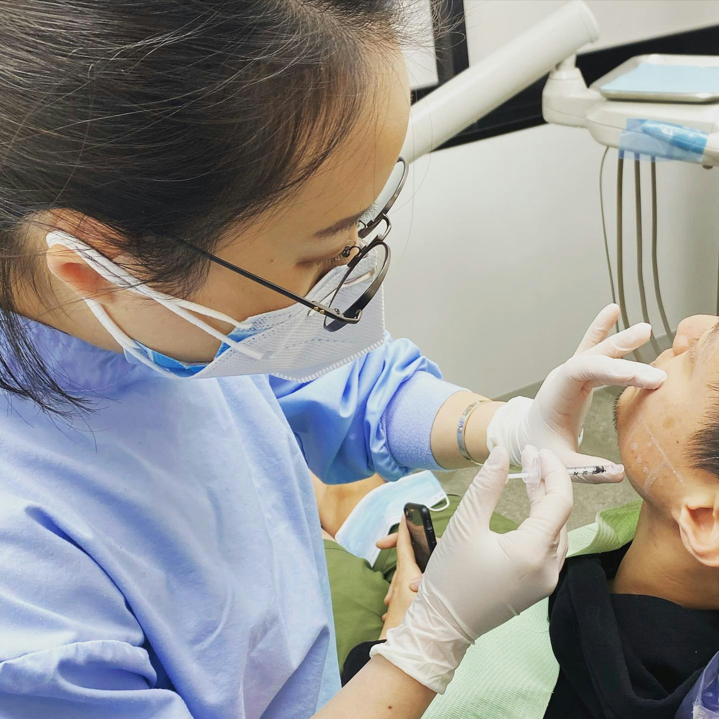 Dr. Min Hee Oh performing TMJ BOTOX treatment on a patient’s jaw